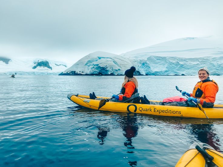 A man and woman kayaking in ANTARCTICA, enjoy and smile