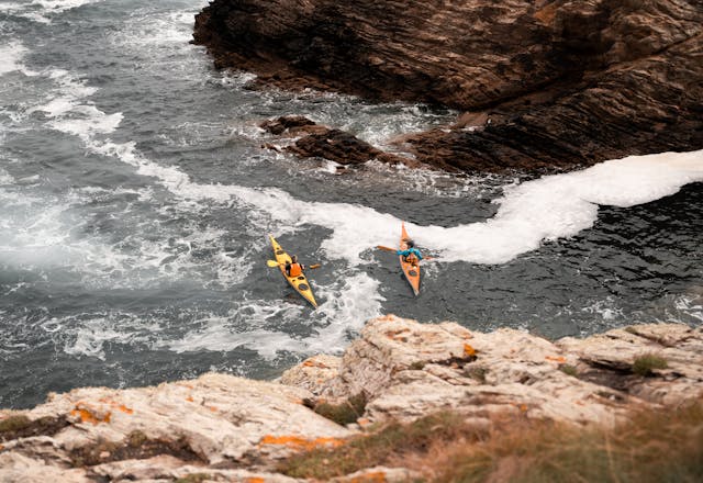 A kayaker navigates around rocks